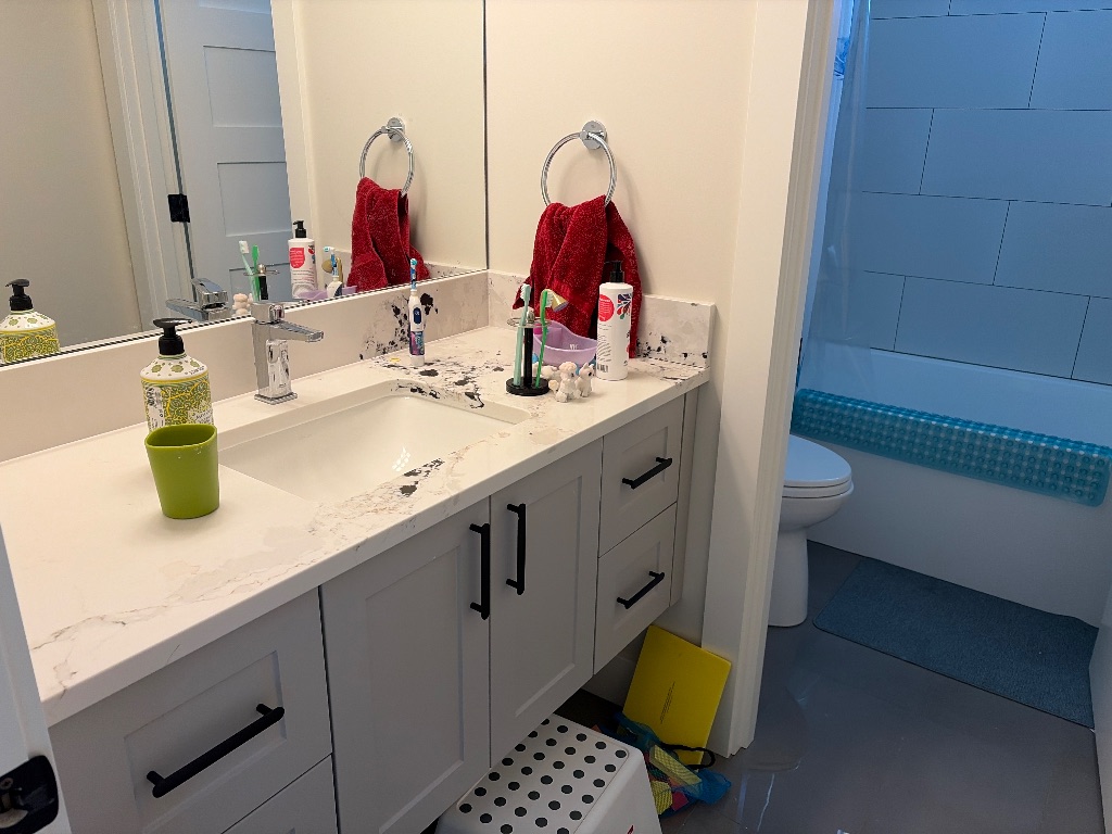 Cluttered bathroom counter before decluttering with items scattered across the surface